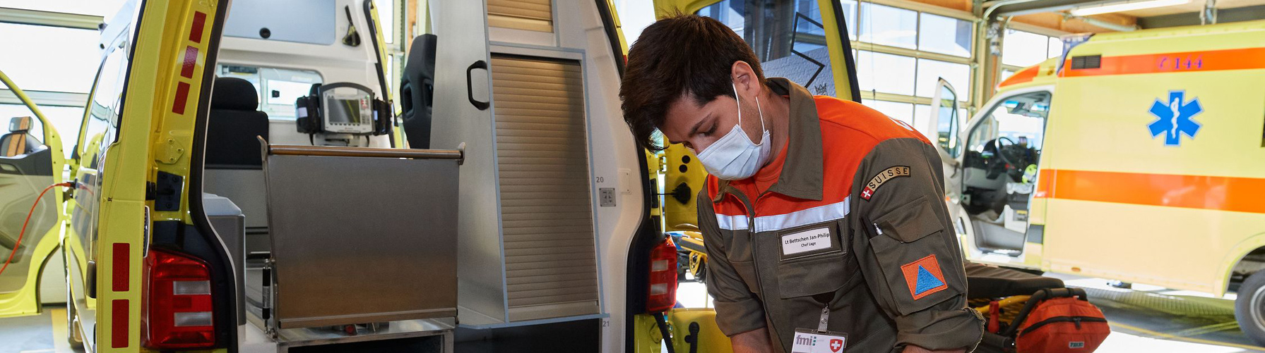 Un préposé à l'assistance désinfecte une ambulance lors de la pandémie COVID-19